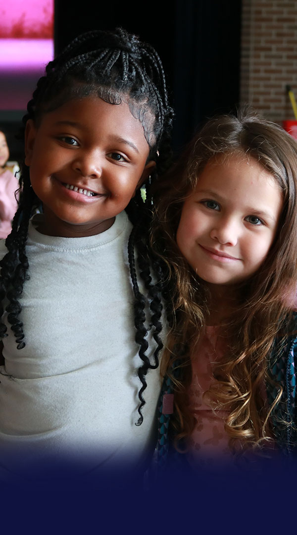 Two Kalamazoo Public Schools students posing for the camera in the cafeteria at Edison Elementary School